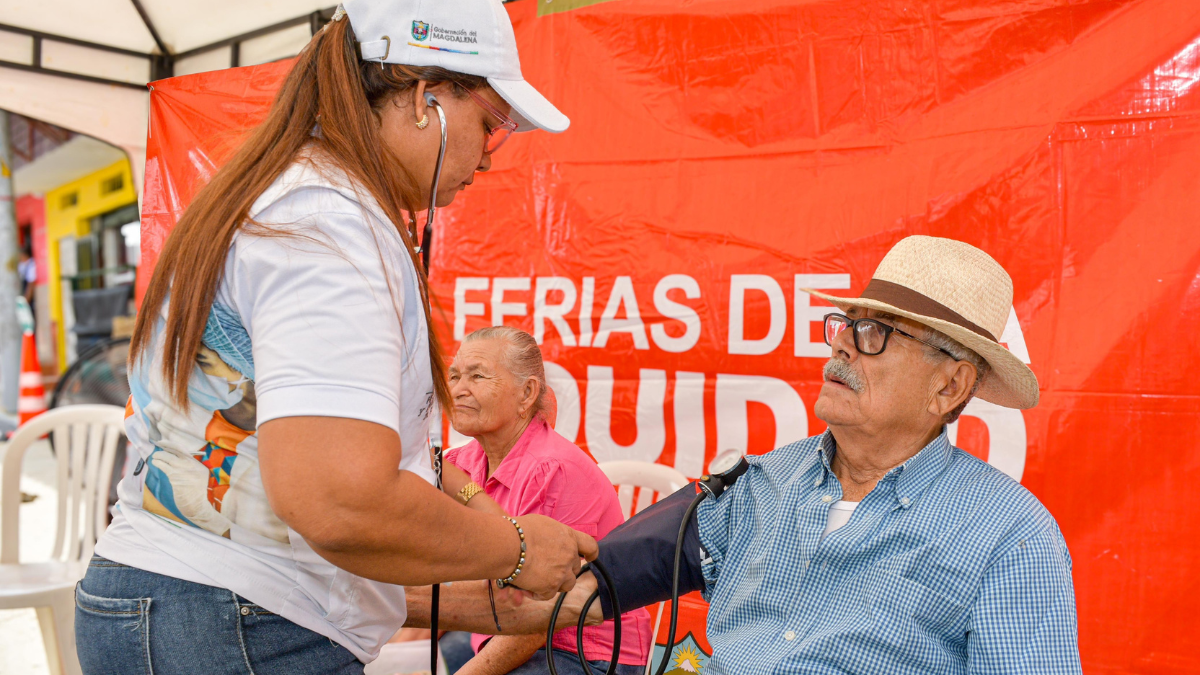 Hombre mayor recibiendo atención de salud de una trabajadora que hace parte del proyecto Feria de la Equidad (Gobernación del Magdalena)